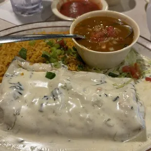 Burrito Alegre covered with queso with borracho beans and rice