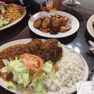 Arroz blanco con frijoles, pollo guisado, ensalada, y platano maduro