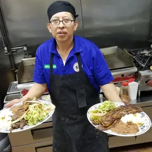 a woman holding two plates of food