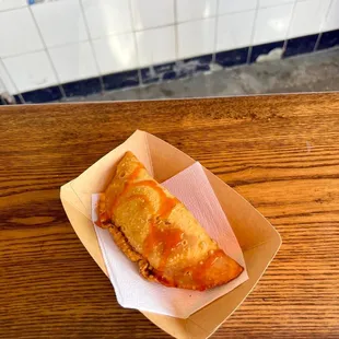 a piece of pizza in a basket on a wooden table