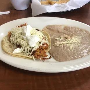 Delicious chicken taco soft shell with a side of beans