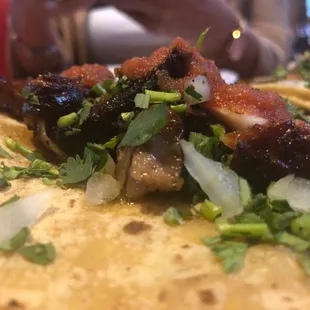 a close up of a taco with meat and onions