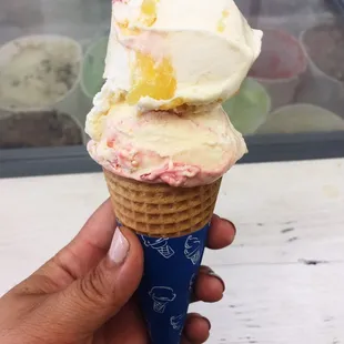 Strawberry cheesecake and pineapple cream ice cream sugar cone.