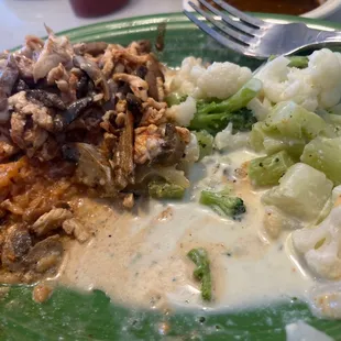 a green plate of food with rice, broccoli, and cauliflower