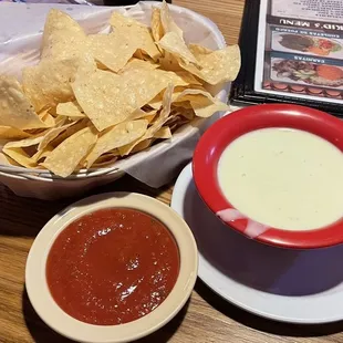 Chips and complimentary salsa plus a large bowl of queso