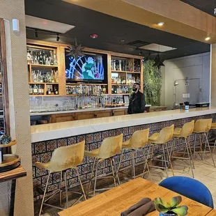 a bar with chairs and a television
