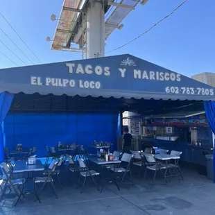 a blue tent with tables and chairs