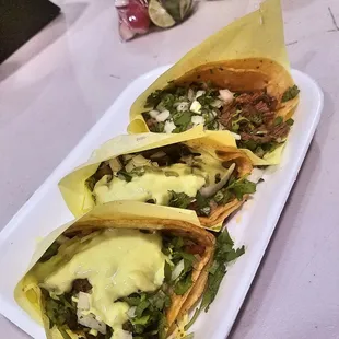 three tacos on a white plate