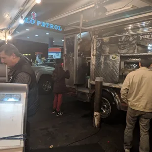 a group of people standing in front of a food truck