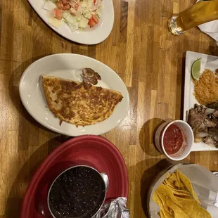 a variety of mexican food on a wooden table