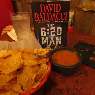 a bowl of chips and a book