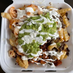a container of nachos with guacamole