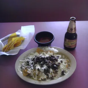 a plate of nachos and a bottle of beer
