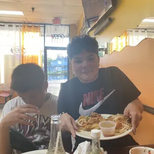two boys eating at a table