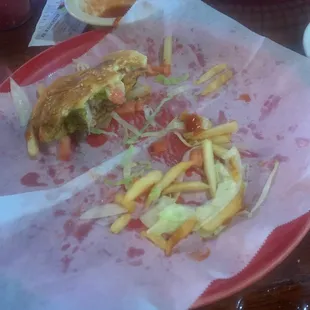 a half eaten sandwich and fries