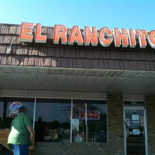 a man standing in front of a restaurant