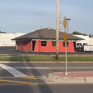 a street corner with a red building in the background