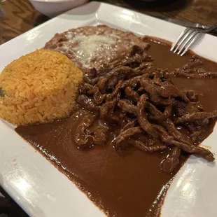 Asado de Rancho-Steak Chopped and cooked in our special Guajillo-Ancho sauce, served with rice and beans.