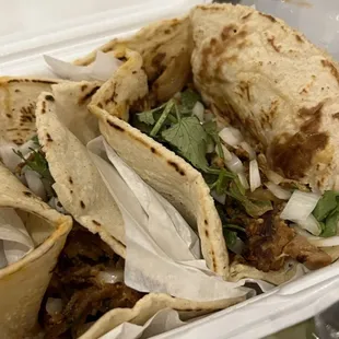 three tacos in a styrofoam container