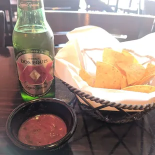 a bowl of chips and a bottle of beer