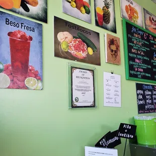 a green wall with posters on it