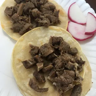 two tacos on a paper plate