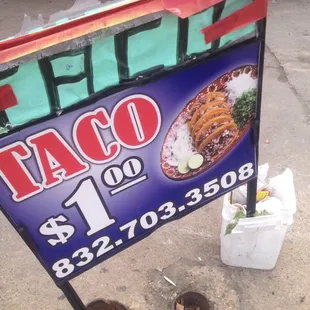 A Tacorriendo sign advertising $1 tacos and their To-Go phone number.