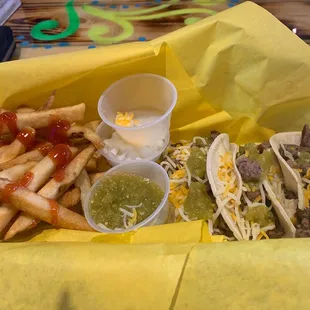 a basket of tacos and fries