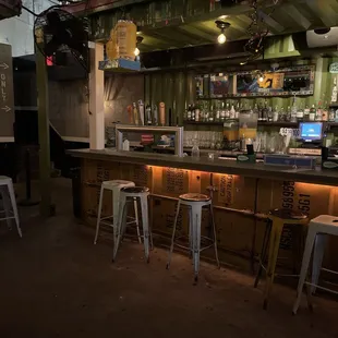 a dimly lit bar with stools