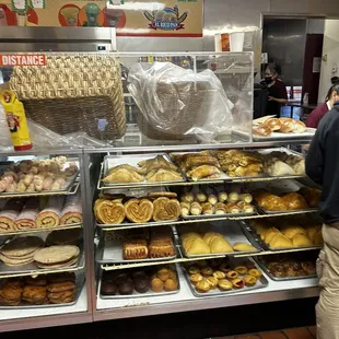a man standing in front of a display of baked goods