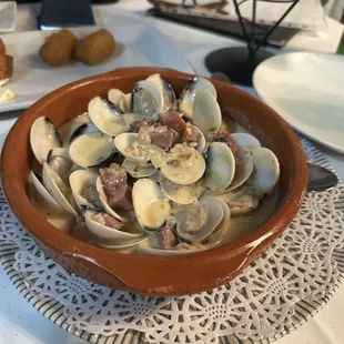 Almejas Con Jamon Serrano, our favorite dish. Clams in a  rich white sauce, hint of wine and the decadent serrano ham flavor