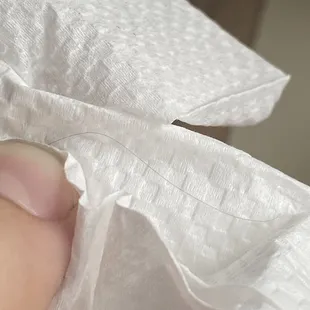 a person&apos;s hand holding a piece of tissue