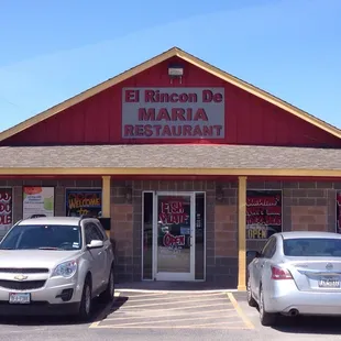 two cars parked in front of a restaurant