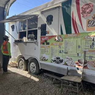Food truck and they have a covered area with 6 tables