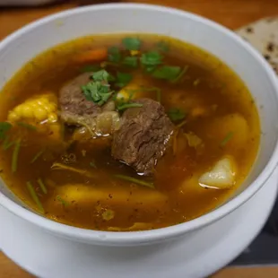 a bowl of soup with meat and vegetables