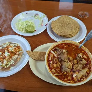 a bowl of soup, tortillas, and a plate of coleslaw