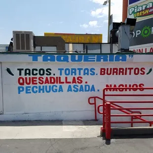a sign for tacos, tortass, burritos, quesadillas, pechu