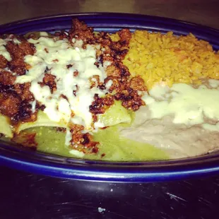 Absolutely to die for pork enchiladas with Salsa verde, Chorizo and cheese, with a side of rice and beans. YUMMY!!