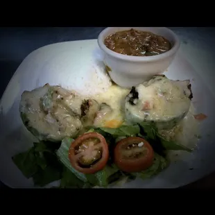 Stuffed avocado, filled with chicken and beef topped with creamy cilantro sauce and Monterey Jack cheese .