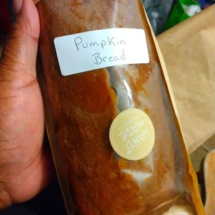 a person holding a bag of pumpkin bread