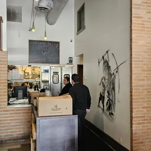 a man standing at a counter in a restaurant