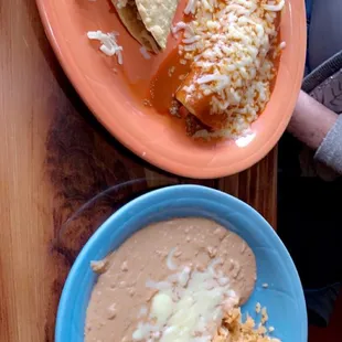 two plates of mexican food on a wooden table