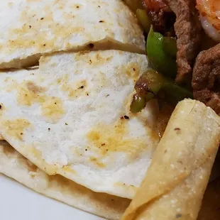 a plate of mexican food including tortillas and shrimp