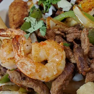a plate of mexican food with shrimp and vegetables