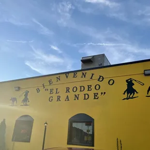 a yellow building with a horse and rider on it