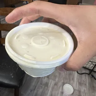 a hand holding a cup of cream