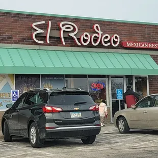 two cars parked in front of a mexican restaurant