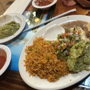 Side of rice and beans, guac and sour cream for fajitas