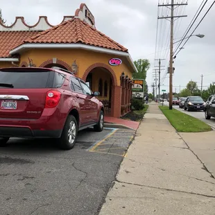 a red car parked in front of a restaurant