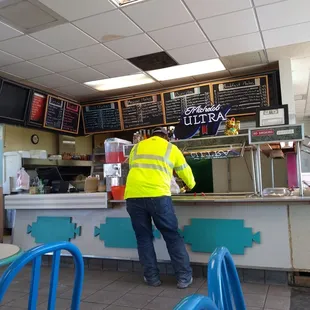 a man standing at a counter in a restaurant